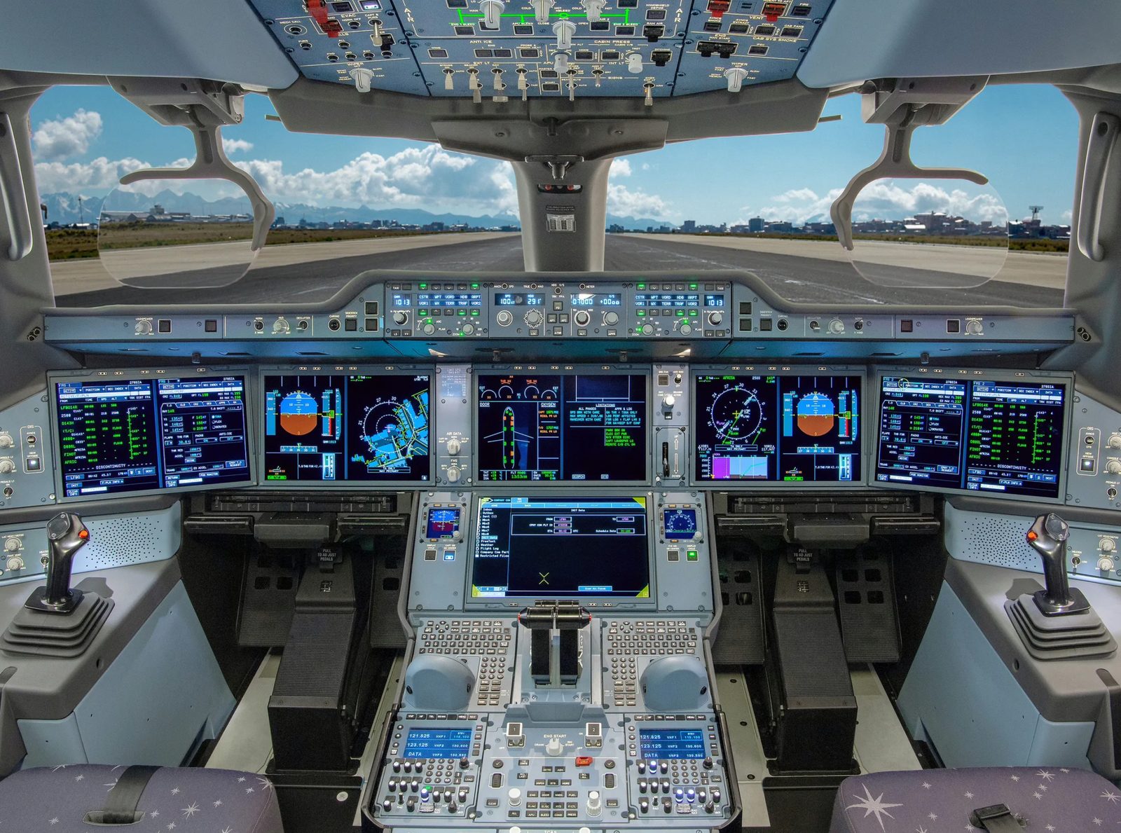 A modern glass flight deck with the runway visible ahead.